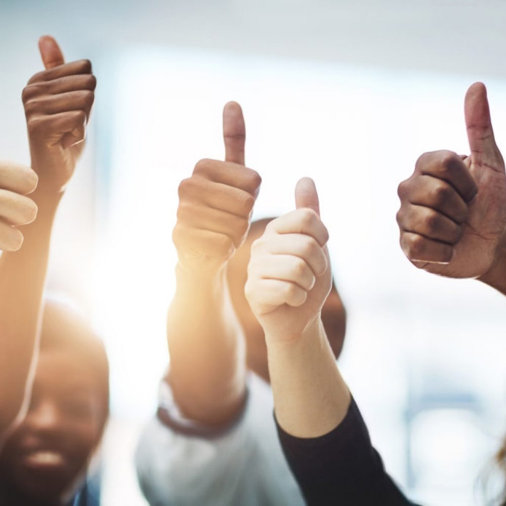 Bravo on your business accomplishment! Cropped shot of a team of colleagues showing thumbs up at work